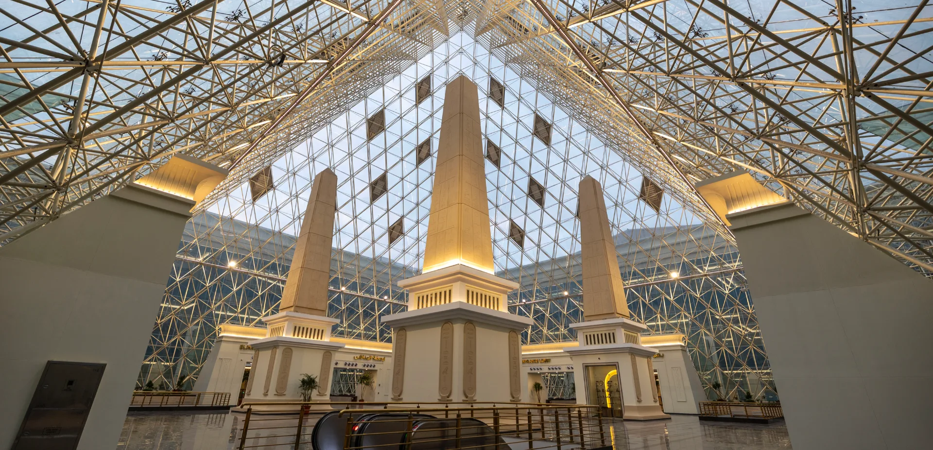 The Prism Complex — glass pyramid atrium with obelisks