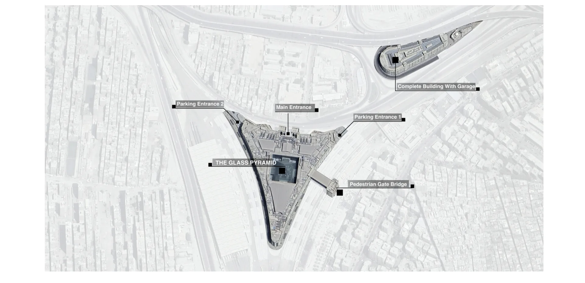 Site aerial — the glass pyramid, entrances and pedestrian gate bridge
